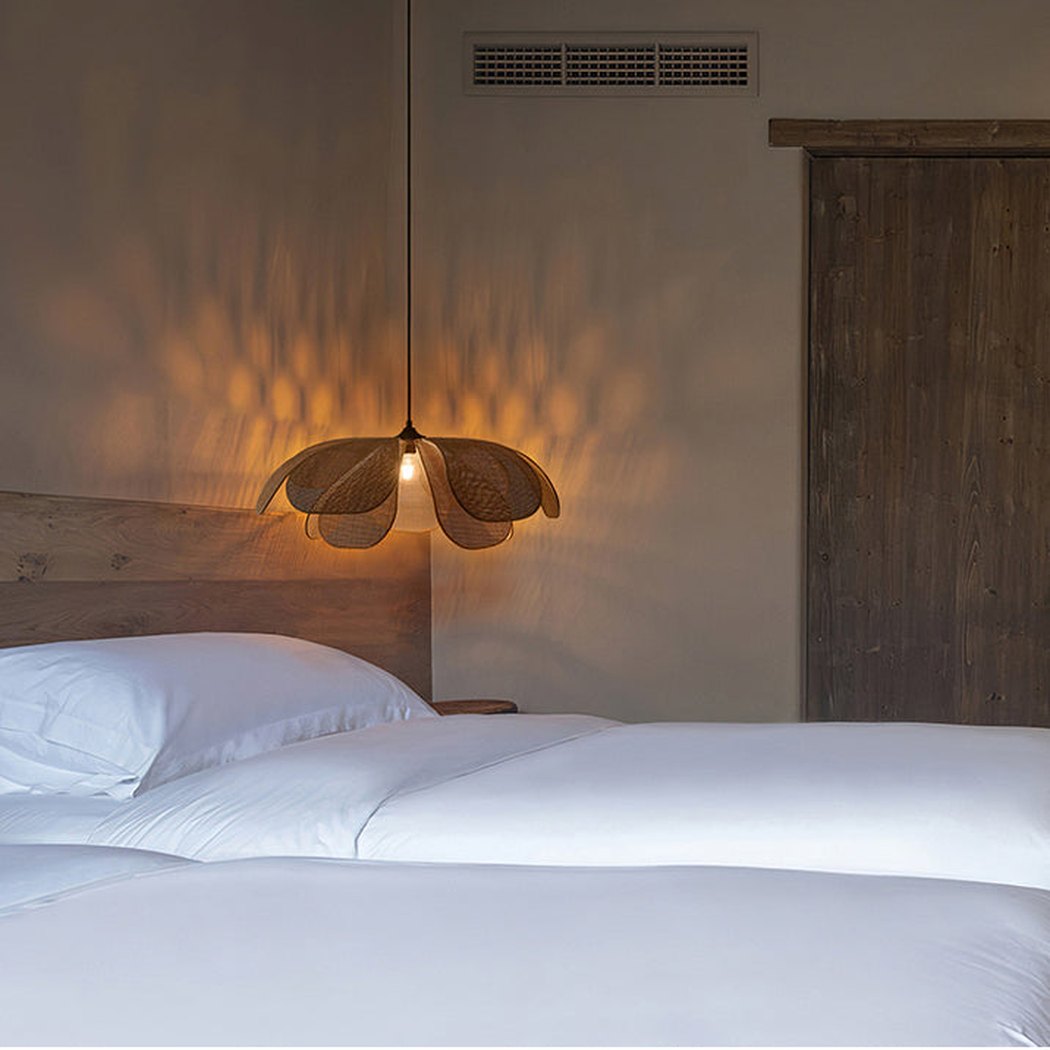 Cefalu Rattan Petals Floral Pendant Light installed as a bedside lamp
